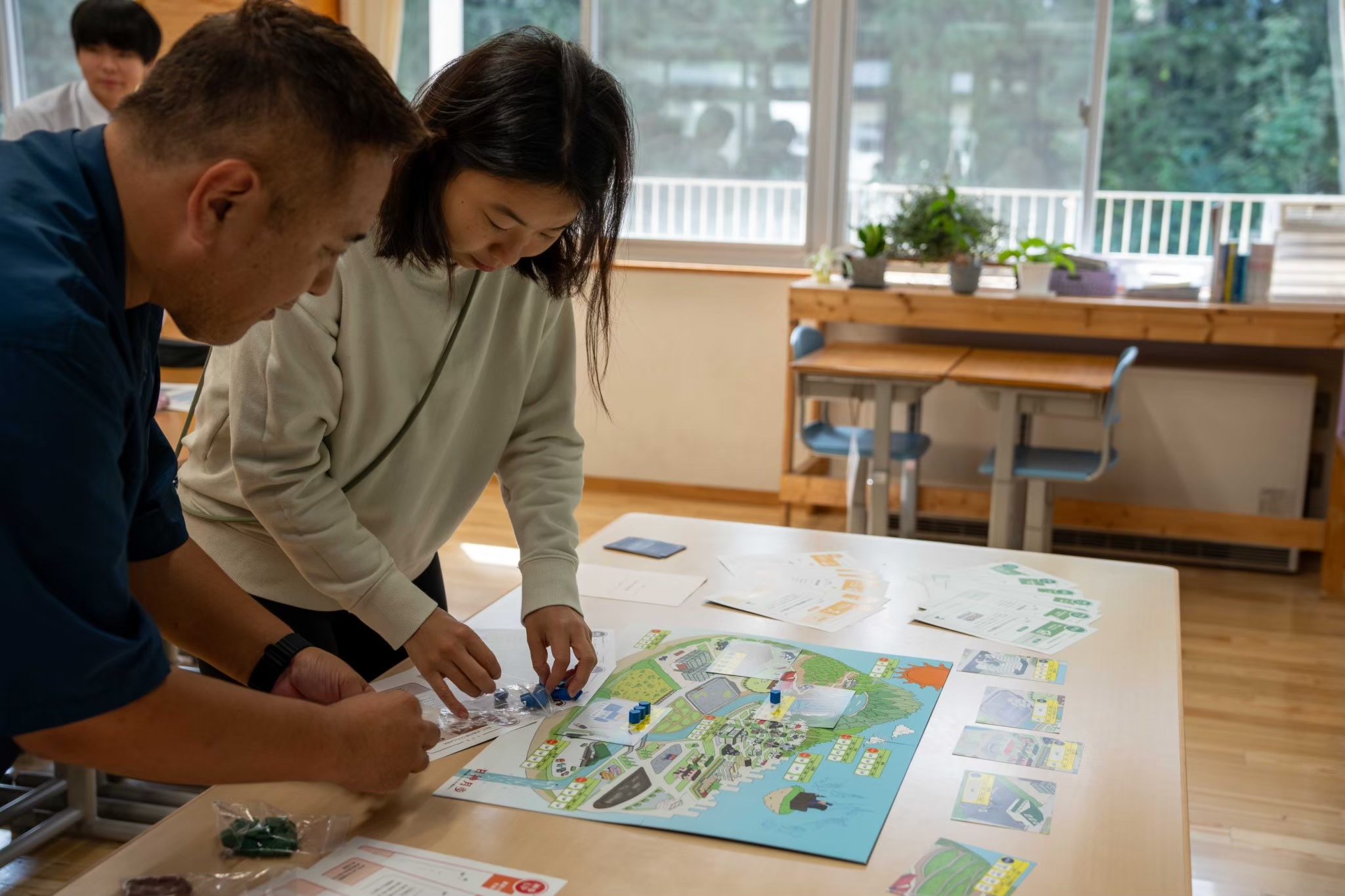 SDGs地方創生桌遊實際遊戲進行中——桌遊盤面展示日本地方地圖，玩家使用彩色棋子、骰子，或是組隊競賽，進行SDGs永續發展目標挑戰